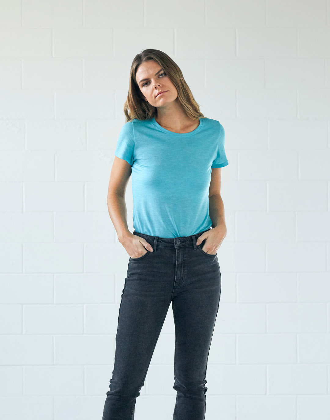 Women in cyan t-shirt and dark grey jeans.